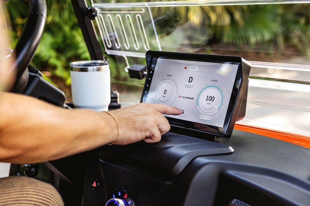 A man driving a truck with a tablet on the dashboard