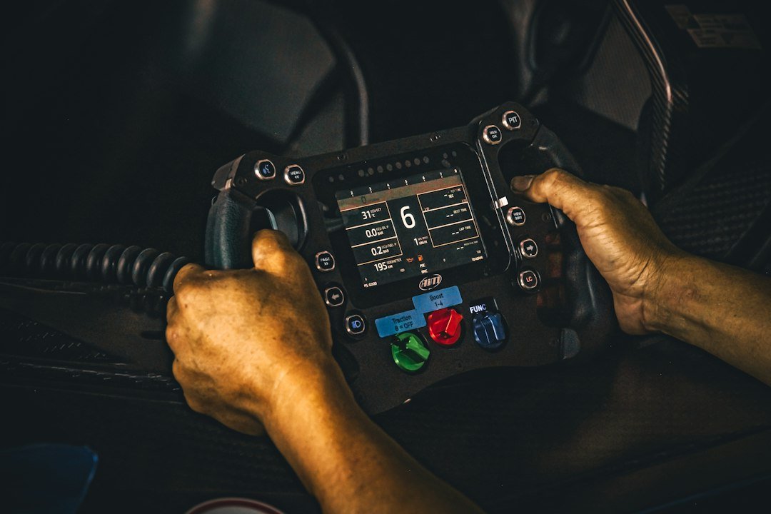 Oily hands hold a professional racing steering wheel